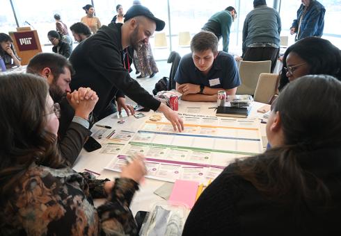 Gathered around several tables, Living Climate Futures Symposium participants worked together to identify potential pros, cons and tradeoffs of allowing a data center to be built in a fictitious community. (Photo by Laura Frye-Levine)